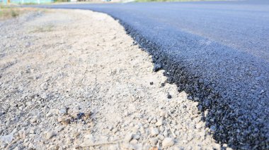 Roadside asphalt edge. Repair of curvy country road with recycled asphalt with copy space. selective focus