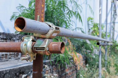 Metal İskele Boru Kıskacı. İnşaat alanındaki çelik boruları ve parçaları tutmak ya da konser sahnesini desteklemek için kullanılan iskele desteğinin yakınlaştırılması. seçici odak