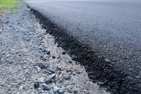 Paved road in side view. Close up of asphalt road surface built or renovated with copy space with selective focus.