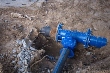 Deliklerde yeni tesisat var. Delikteki mavi metal tesisat borusuna yakın çekim. Yan görüntüde plastik boru bağlantısı için bekliyor.