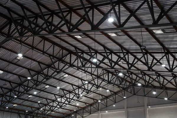 Hanging lamp with roof structure. Ceiling lights that illuminate the exhibition hall hang beneath a light metal roof structure with copy space with selective focus.