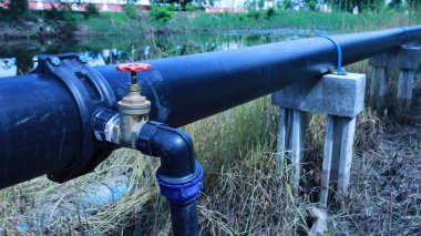 Hdpe borusunda su vanası var. Saddle Clamp bağlantısındaki su kesme vanası, tüketicilere ana su borusundan fotokopi alanı ve odak seçimi olan beton iskele üzerindeki su tedarik etme noktasını gösteriyor.