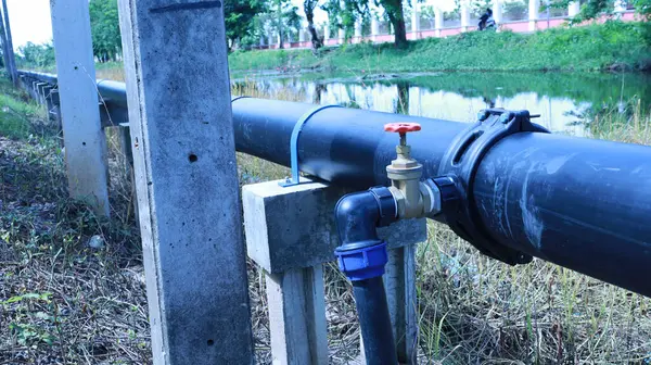 Hdpe borusunda su vanası var. Saddle Clamp bağlantısındaki su kesme vanası, tüketicilere ana su borusundan fotokopi alanı ve odak seçimi olan beton iskele üzerindeki su tedarik etme noktasını gösteriyor.