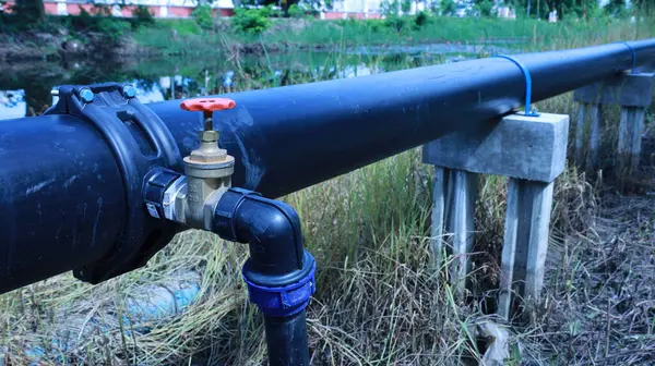 Hdpe borusunda su vanası var. Saddle Clamp bağlantısındaki su kesme vanası, tüketicilere ana su borusundan fotokopi alanı ve odak seçimi olan beton iskele üzerindeki su tedarik etme noktasını gösteriyor.