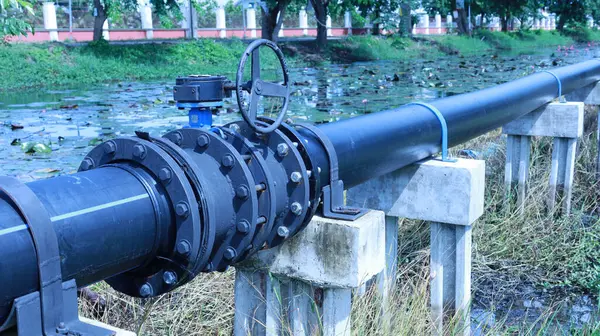 Hdpe boru bağlantısında kelebek kapakçığı. Kopya alanı ve seçici odaklı drenaj kanalının yanındaki beton iskelede elle kapatma vanası..