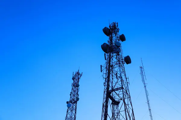 Telekomünikasyon kulesi silueti. Telekomünikasyon kulesi mavi gökyüzüne karşı kablosuz teknoloji teçhizatı ile fotokopi alanı ile alt görüntüde. Seçici odak