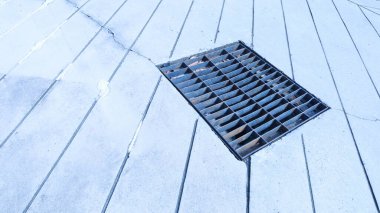 Kaldırımda metal ızgara var. Çelik drenaj ızgarası, dışarıdaki beton zemindeki ana drenajı fotokopi alanıyla kapatır. Seçici odak