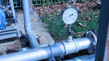 Su basıncı göstergesi boruda. Su basıncı göstergesi psi de, sualtı vanası da beton zemine yerleştirilmiş ve fotokopi alanı var. Seçici odak