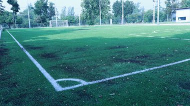 Yapay çim futbol sahası. Yapay çim futbol sahasının köşesindeki beyaz çizgi. Açık hava sporları için fotokopi alanı olan çitler var. Seçici odak
