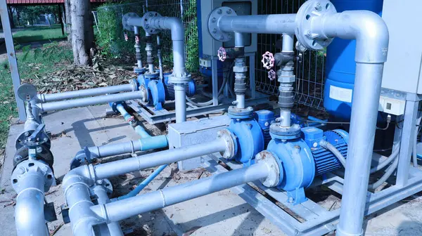 Pompa ve motor. Metal çitlerin yanına beton zemin üzerine kurulmuş yerleşim binasına su sağlamak için otomatik su kontrol borusuyla su pompası istasyonunu kapatın. Seçici odak