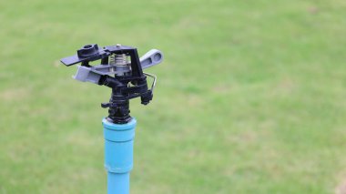 Bahçede fıskiye başı var. Sulama sistemi için fıskiye başlığının fotokopi alanı ve seçici odak noktası ile çimleri sulamak için yakın plan görüntüsü