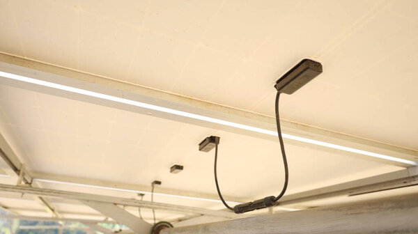 Провода под солнечными панелями. Солнечные фотоэлектрические разъемы солнечных схем и проводов под солнечными панелями в смарт-ферме с низким углом обзора с копировальным пространством и выборочной фокусировкой.