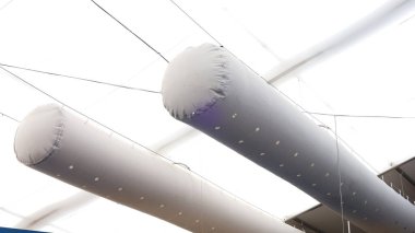 Frabic havalandırma kanalı. Beyaz tuval kubbede asılı gri ikiz kumaş hava kanallarını seçici odaklı düşük açıyla kapatın..