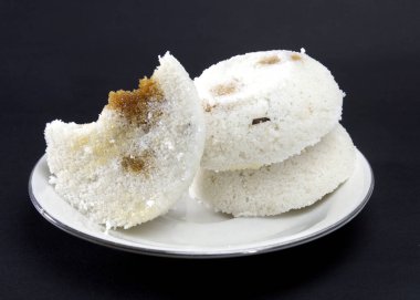 Steamed Rice Cake or Bhapa Pitha is a traditional dish of Bangladesh. Winter rice cake on Black Background. bite or broken pitha. Ingredients are rice powder, molasses, coconut, sugar etc. clipart