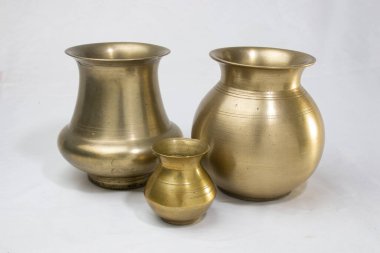 Beyaz arka planda izole edilmiş dini Hint festivallerinde geleneksel ayinler için su kabı olarak kullanılan boş altın pirinç kaplar..