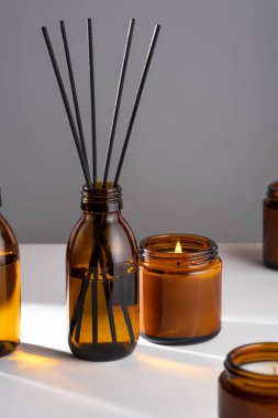 Aroma yayıcı. Kahverengi cam şişede doğal yağ var. Kehribar kavanozunda alev bulunan soya mumu. Akıl sağlığını, sakinliği ve uyumu hesaba katın. Kaba, minimalizm.