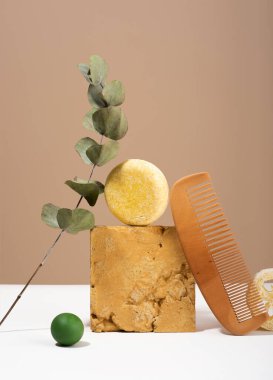 Hala modern yaşam kompozisyonu. Sağlam şampuan barı ve doğal malzemeler bir fikir dengesi. Tahta tarak, Luffa Sponge, bej arka planda okaliptüs. Plastiksiz, sıfır atık, düşük su bileşenleri.