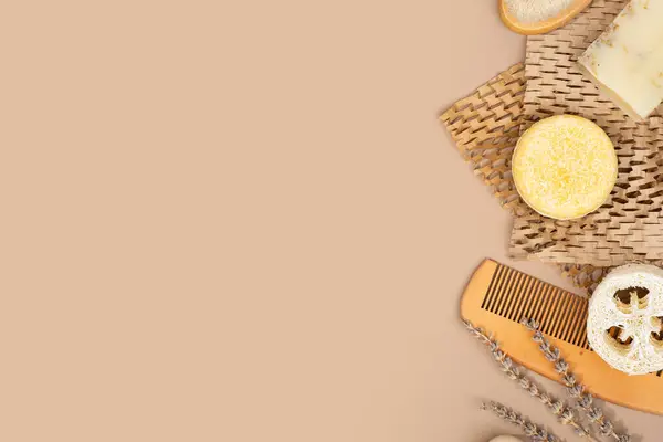 Sustainable solid shampoo bar and wooden comb lying on a Honeycomb Paper and coffee brown colored background. Hair care. Plastic free, zero waste living, low water ingredients. Copy space.