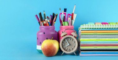 Okul malzemeleri mavi arka planda izole edilmiş. Okula geri dön renkli konsept