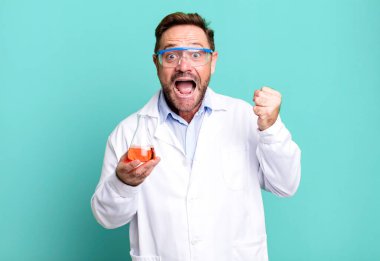 Orta yaşlı adam şokta, gülüyor ve başarıyı kutluyor. Bilim adamı konsepti