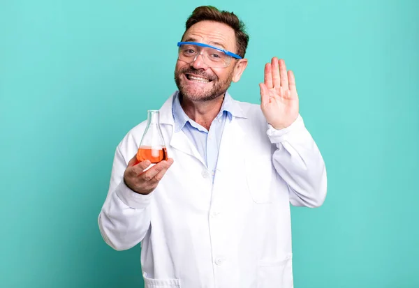 middle age man smiling happily, waving hand, welcoming and greeting you. scientist concept