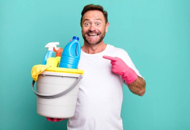 Orta yaşlı adam heyecanlı ve şaşırmış görünüyor. Temiz ürünleri olan bir hizmetçi.