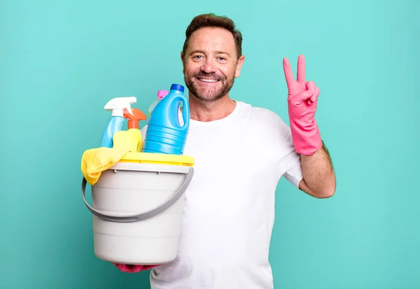 中年男性の笑顔と友好的に見える 2番目を示す 掃除用品付きの家政婦 — ストック写真