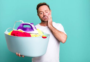 Kirli çamaşır sepeti spor koçu konsepti ve futbol topuyla orta yaşlı hizmetçi konsepti.