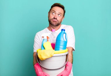 Orta yaşlı erkek temizlikçi kavramı ile temiz ürünler spor koçu kavramı futbol topu ile