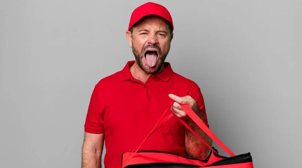 中年の男はうんざりしていらいらして舌を出す ピザ配達の男 — ストック写真