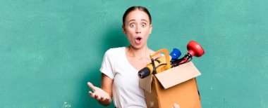 caucasian pretty woman feeling extremely shocked and surprised with a tool box. repair home concept