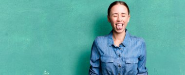 caucasian pretty woman with cheerful and rebellious attitude, joking and sticking tongue out