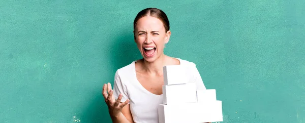 白人女性は怒っていらいらしながら白い箱のパッケージに不満を感じています — ストック写真