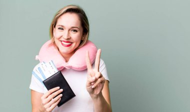 smiling and looking friendly, showing number two. flight passenger concept