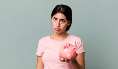 feeling sad and whiney with an unhappy look and crying. with a piggy bank