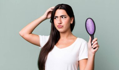 smiling happily and daydreaming or doubting. hair comb concept