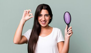 feeling happy, showing approval with okay gesture. hair comb concept