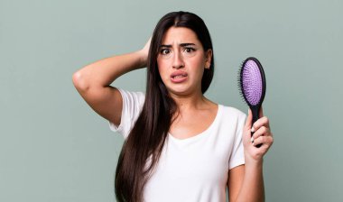 feeling stressed, anxious or scared, with hands on head. hair comb concept