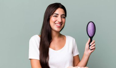 smiling cheerfully, feeling happy and showing a concept. hair comb concept