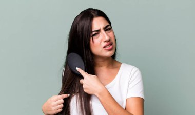 pretty hispanic woman using a hair comb
