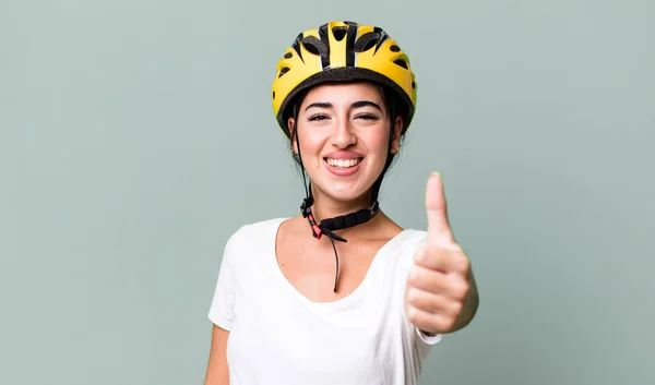 feeling proud,smiling positively with thumbs up. bike helmet concept