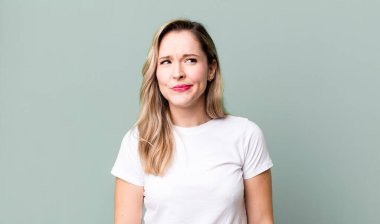 Şaşırmış ve kafası karışmış görünüyor, merak ediyor ya da bir sorunu çözmeye çalışıyor.