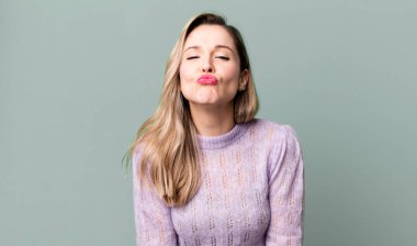 Sevimli, eğlenceli, mutlu, sevimli bir yüz ifadesiyle dudakları birbirine bastırmak, öpücük göndermek.