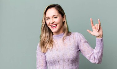 Mutlu, eğlenceli, kendinden emin, pozitif ve isyankar hissediyorum, elle kaya ya da heavy metal işareti yapıyorum.