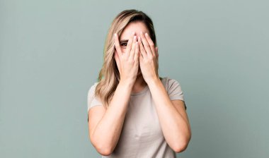 Yüzü ellerle kaplamak, parmaklarının arasından bakmak şaşırmış bir ifadeyle yan tarafa bakmak.