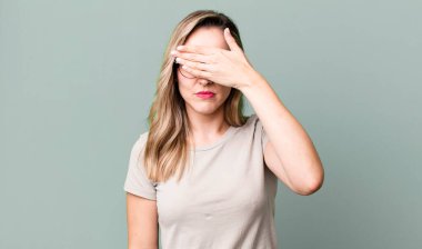 Bir eliyle gözlerini kapatıyor korkmuş ya da endişeli, merak ediyor ya da körü körüne bir sürpriz bekliyor.