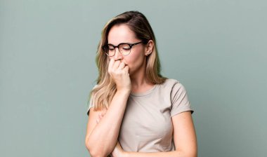 Ciddi, düşünceli ve endişeli hissediyorum. Elleri çenesine değmiş şekilde yan yan bakıyor.