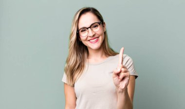 Gülümsüyor ve dost canlısı görünüyor, bir numara veya ilk eli önde, geriye doğru sayıyor.