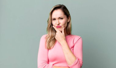 Ciddi görünüyor, kafası karışık, kararsız ve düşünceli, seçenekler ve seçimler arasında şüpheci