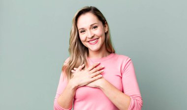 Romantik, mutlu ve aşık, neşeyle gülümseyen ve kalbe yakın el ele tutuşan